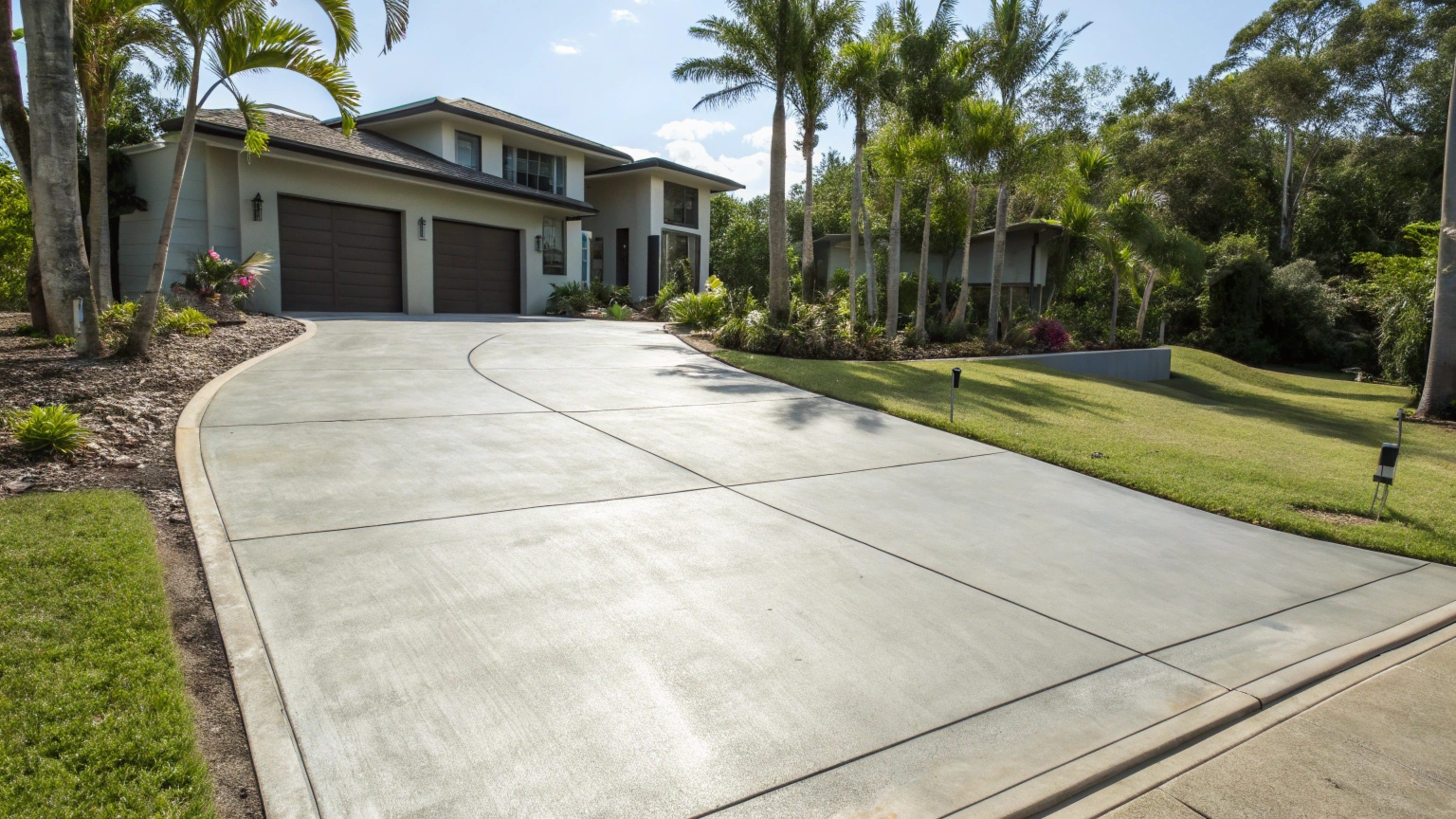 Professional concrete driveway installation Tinana QLD with smooth finish and tropical landscaping