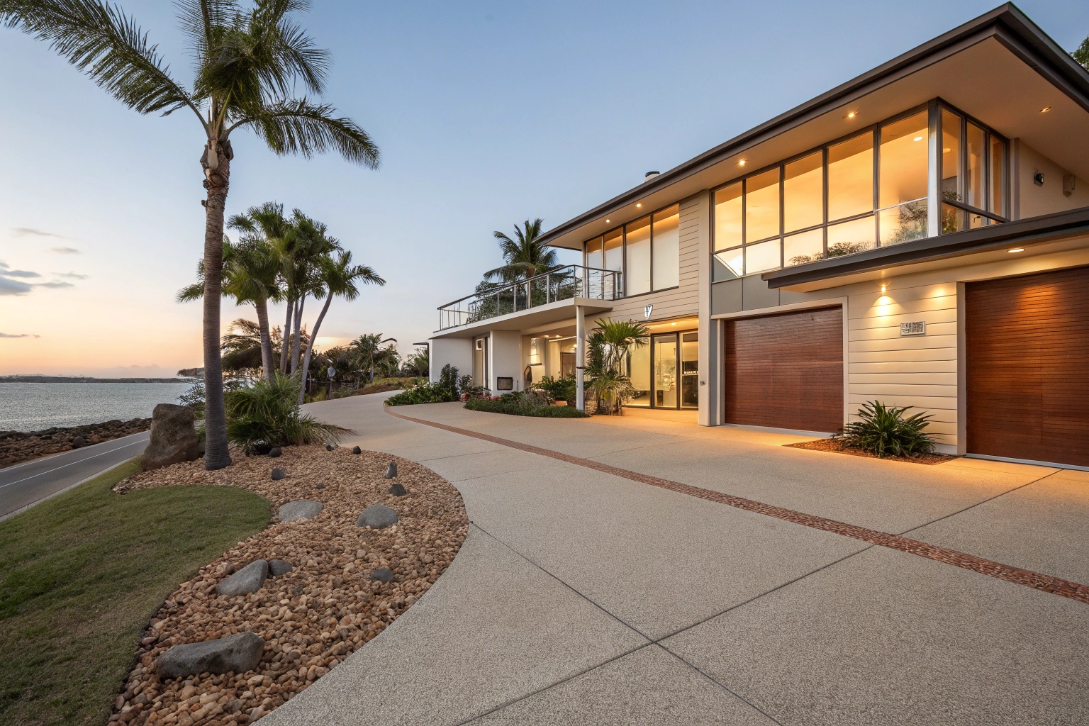Exposed aggregate concrete driveway at modern Torquay coastal home with palm trees